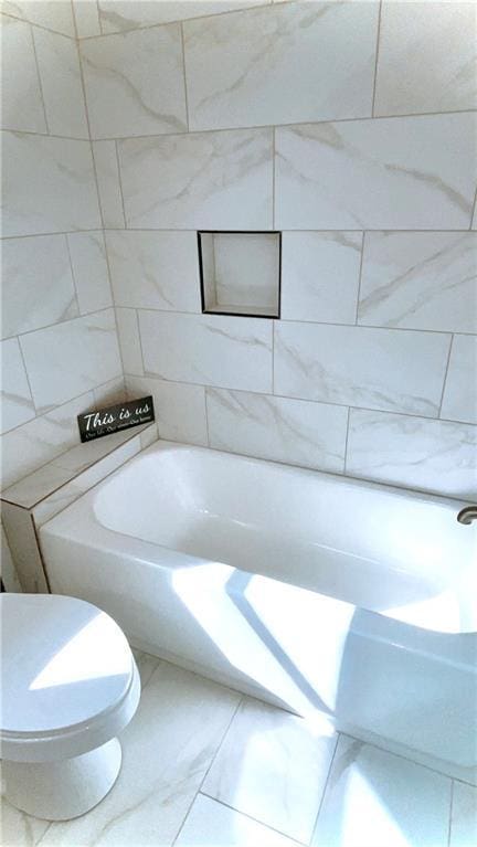 full bathroom featuring a tub to relax in and toilet