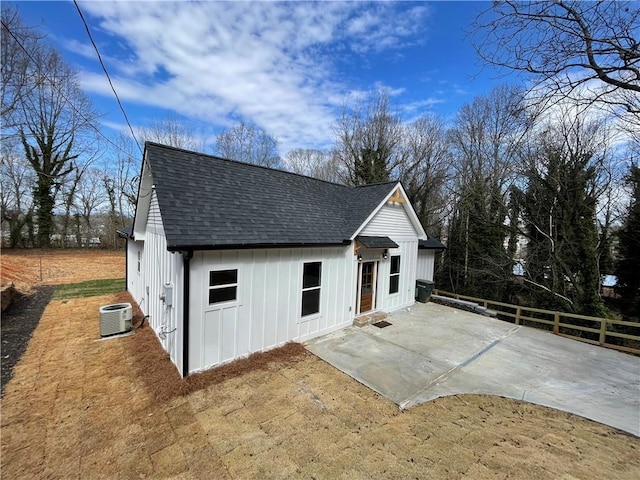 view of home's exterior with a patio area, a shingled roof, and cooling unit