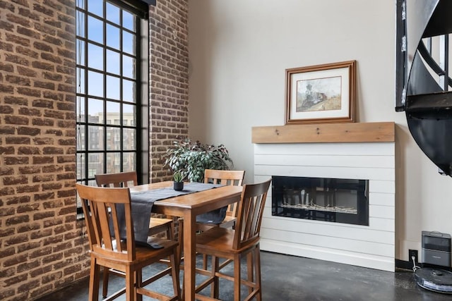 dining room with brick wall and a wealth of natural light