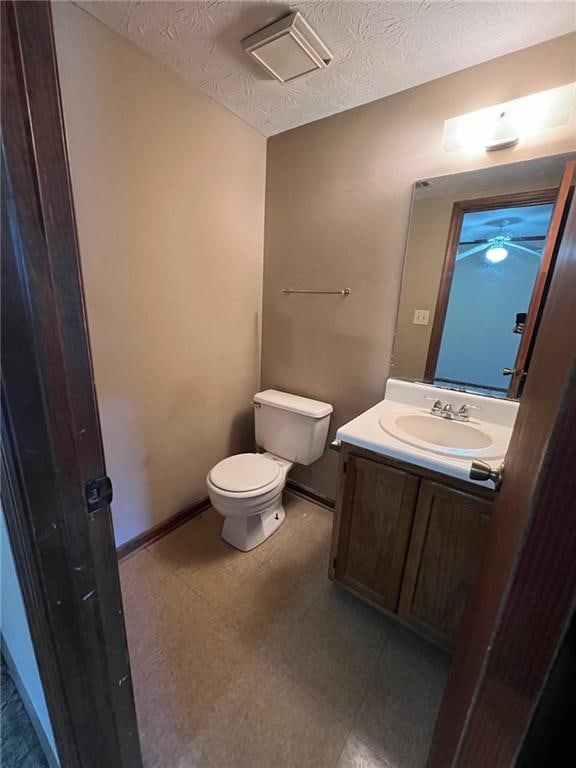 bathroom featuring vanity, toilet, and a textured ceiling