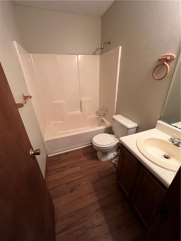 full bathroom with toilet, hardwood / wood-style floors, vanity, and bathing tub / shower combination