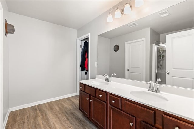 bathroom featuring hardwood / wood-style floors, vanity, and a shower with door