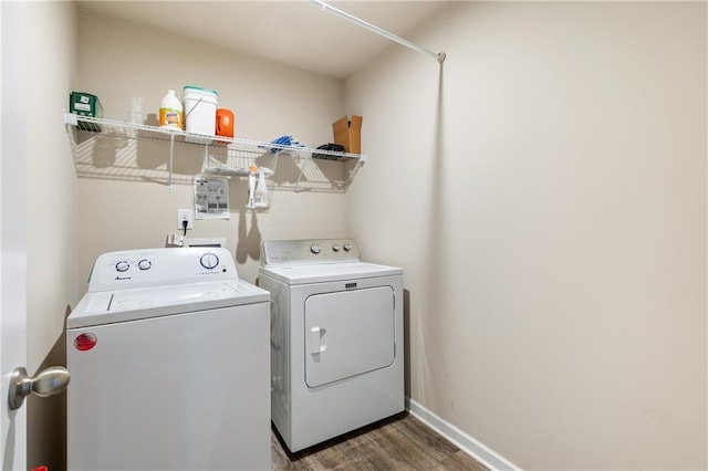 clothes washing area with washer and dryer and dark hardwood / wood-style flooring