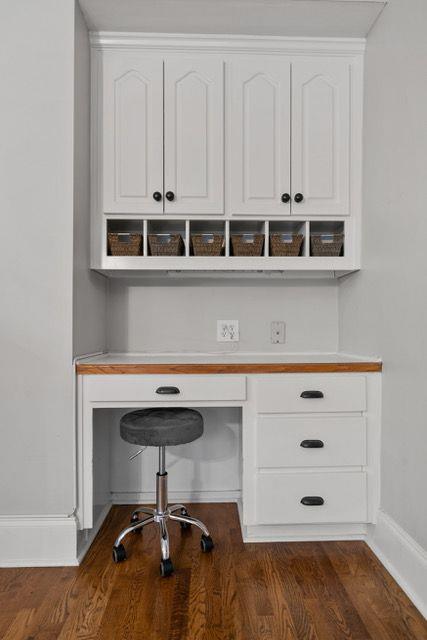 office space with dark wood finished floors, built in desk, and baseboards