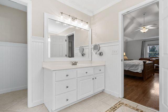 bathroom featuring vanity, tile patterned floors, ceiling fan, and crown molding