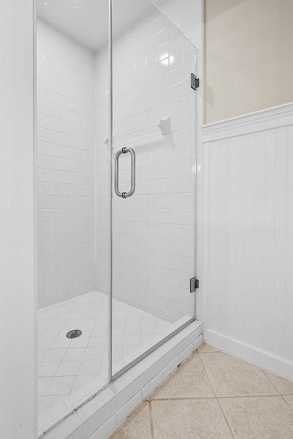 bathroom featuring tile patterned flooring and an enclosed shower