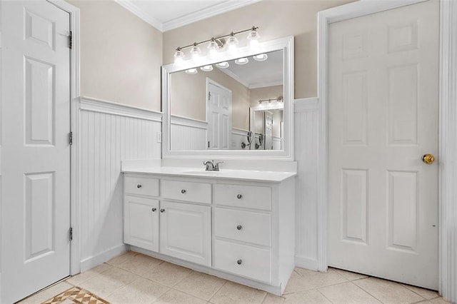 bathroom featuring a wainscoted wall, crown molding, and tile patterned floors