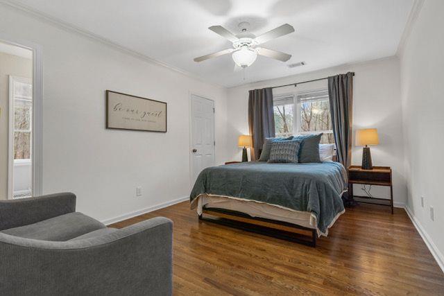 bedroom featuring ceiling fan, dark hardwood / wood-style flooring, and ornamental molding