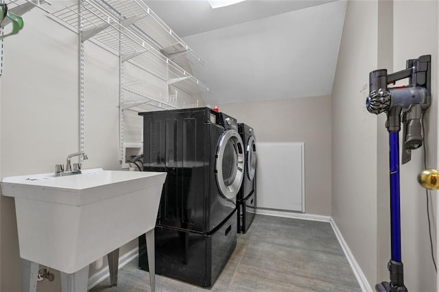 laundry room with laundry area, baseboards, independent washer and dryer, and a sink