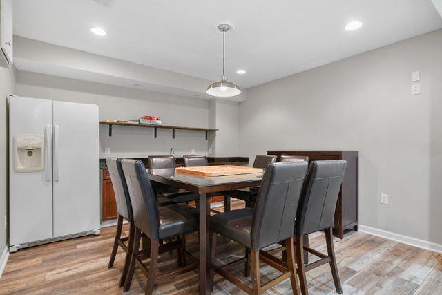 dining room with bar and light hardwood / wood-style flooring