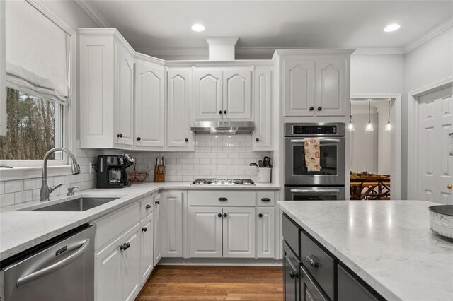 kitchen featuring appliances with stainless steel finishes, tasteful backsplash, sink, white cabinets, and dark hardwood / wood-style floors