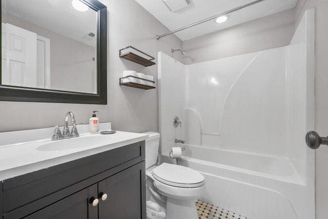 full bath featuring washtub / shower combination, visible vents, vanity, and toilet