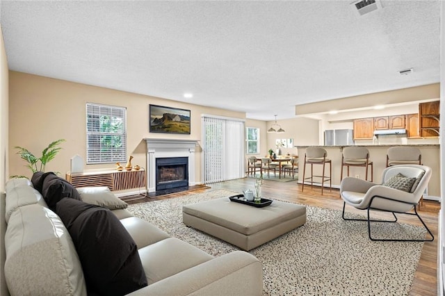 98 Hampshire Ct, Avondale Estates, GA 30002 - living room featuring a textured ceiling, healthy amount of natural light, wood finished floors, a fireplace with flush hearth, and recessed lighting