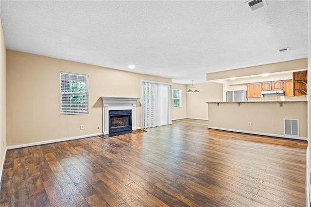 98 Hampshire Ct, Avondale Estates, GA 30002 - unfurnished living room with plenty of natural light, a textured ceiling, wood-type flooring, baseboards, and a fireplace