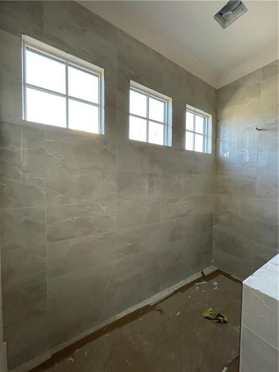 bathroom with plenty of natural light and a tile shower