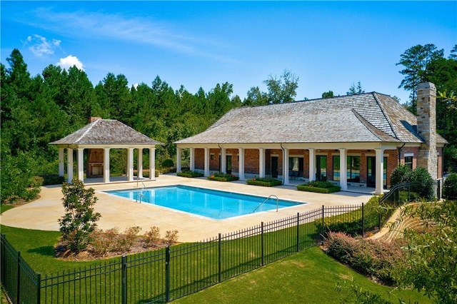 view of swimming pool featuring a gazebo, a yard, a patio area, and an outbuilding