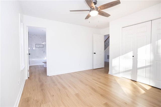 unfurnished bedroom featuring ceiling fan, ensuite bathroom, a closet, and light hardwood / wood-style floors