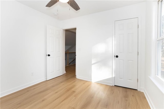 unfurnished bedroom featuring ceiling fan, a closet, and light wood-type flooring