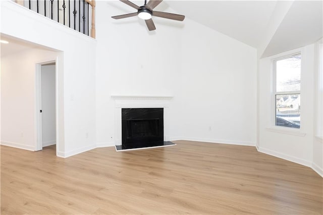 unfurnished living room featuring ceiling fan, light wood-type flooring, and high vaulted ceiling