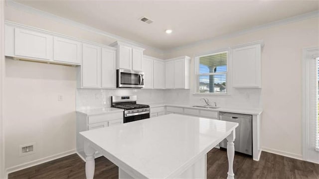 kitchen with stainless steel appliances, sink, dark wood-type flooring, and white cabinets