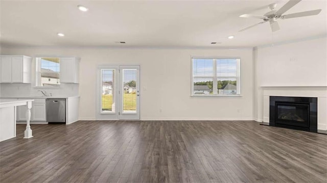 unfurnished living room featuring ceiling fan, dark hardwood / wood-style floors, and sink