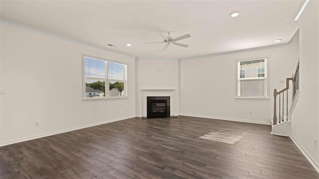 unfurnished living room with crown molding, dark wood-type flooring, and ceiling fan