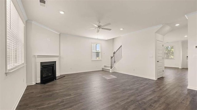 unfurnished living room featuring dark wood-type flooring, ornamental molding, ceiling fan, and plenty of natural light