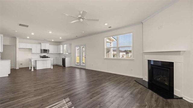 unfurnished living room with ornamental molding, dark hardwood / wood-style floors, and ceiling fan