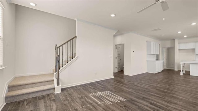 unfurnished living room featuring dark wood-type flooring and ceiling fan