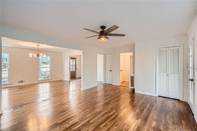 interior space featuring dark hardwood / wood-style flooring, ceiling fan with notable chandelier, and ornamental molding