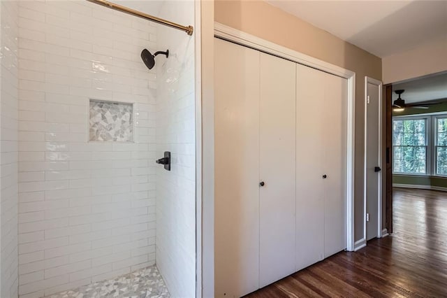 bathroom featuring ceiling fan, wood-type flooring, and tiled shower