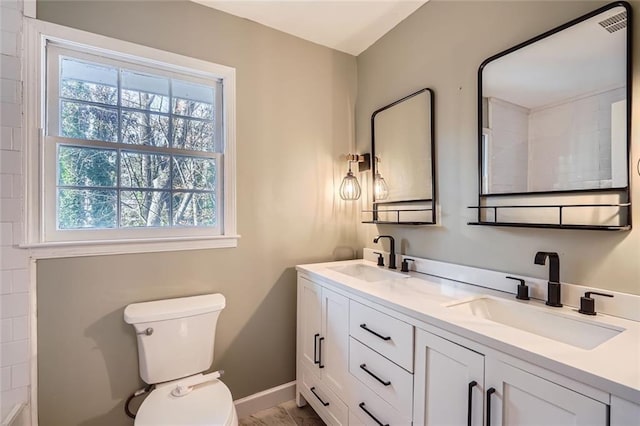 bathroom featuring vanity, toilet, and plenty of natural light