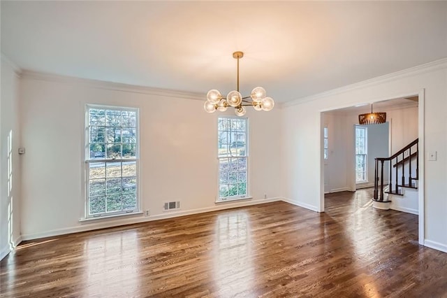 spare room featuring dark hardwood / wood-style floors, ornamental molding, and an inviting chandelier