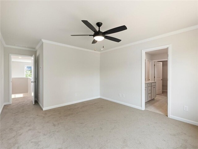 interior space featuring light carpet, connected bathroom, ceiling fan, and ornamental molding