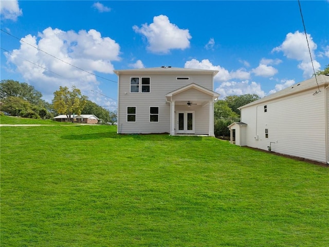 back of property featuring a lawn and ceiling fan