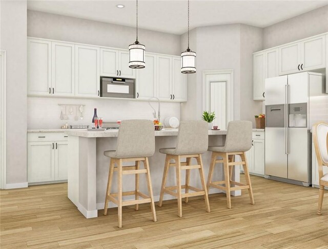 kitchen featuring decorative light fixtures, appliances with stainless steel finishes, light wood-type flooring, and white cabinets