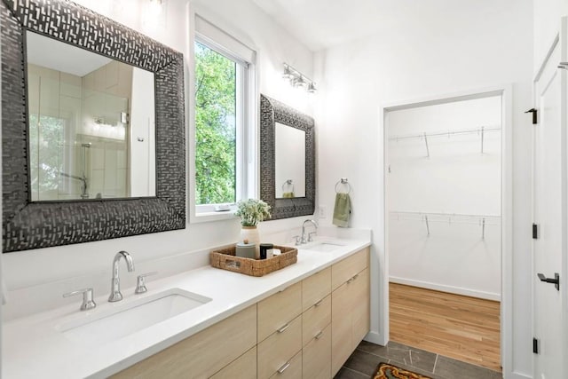 bathroom with vanity, hardwood / wood-style flooring, a wealth of natural light, and walk in shower