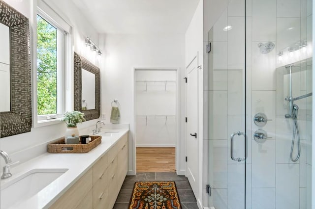 bathroom featuring vanity, plenty of natural light, tile patterned floors, and walk in shower