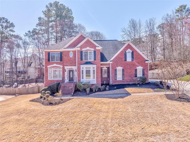 view of front of house featuring a front yard, fence, and brick siding