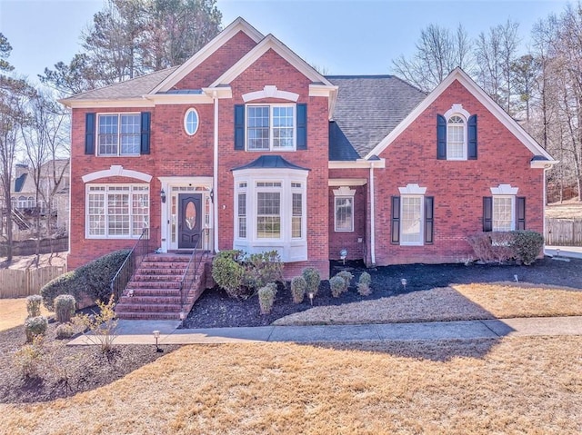 view of front of property featuring brick siding and fence