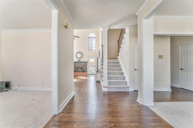 entryway with decorative columns, baseboards, wood finished floors, stairs, and crown molding