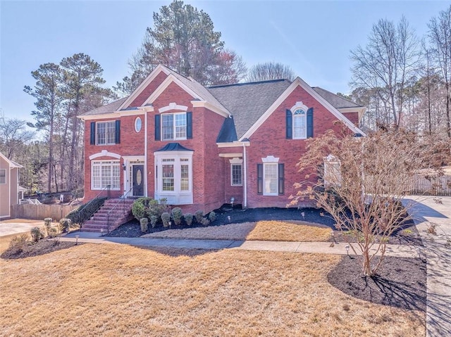 view of front facade featuring brick siding and a front lawn