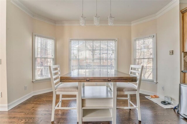 kitchen with dark wood finished floors, crown molding, stainless steel appliances, a sink, and dark stone countertops