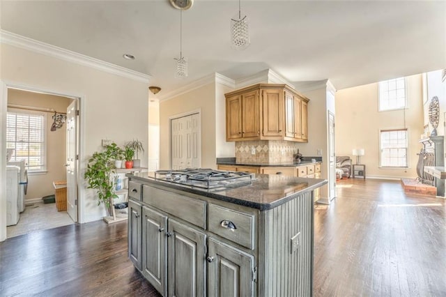 kitchen with tasteful backsplash, plenty of natural light, dark wood finished floors, and stainless steel gas stovetop