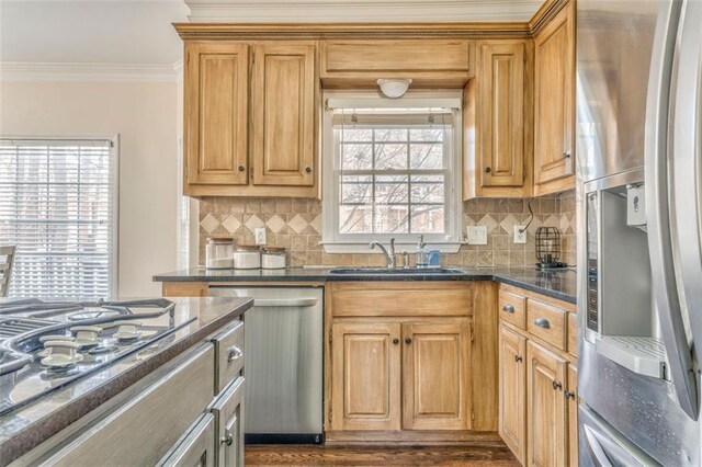 kitchen with a center island, ornamental molding, appliances with stainless steel finishes, decorative backsplash, and dark wood finished floors