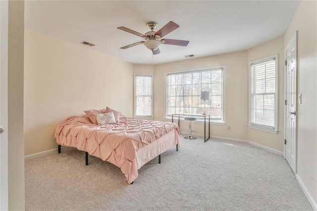 carpeted bedroom featuring ceiling fan, visible vents, and baseboards