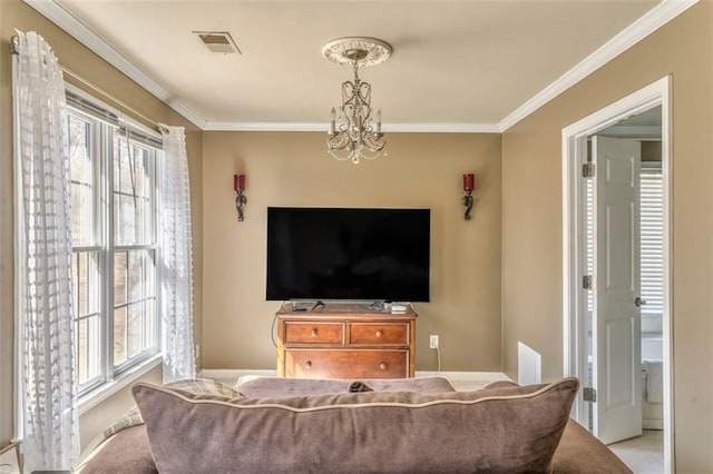 living room with ornamental molding, a healthy amount of sunlight, visible vents, and an inviting chandelier