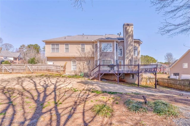 back of property with stairway, a fenced backyard, a chimney, and a wooden deck