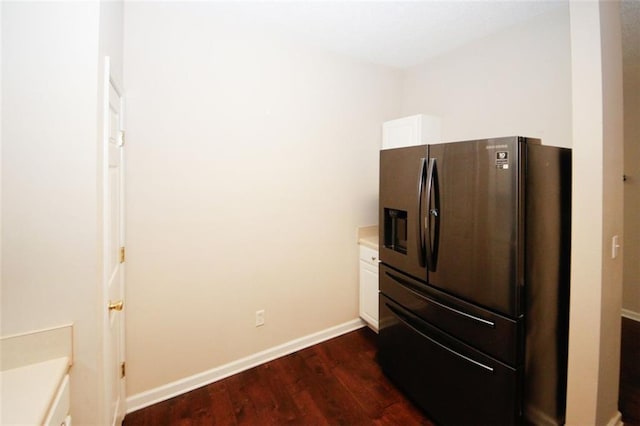 details with stainless steel fridge, dark hardwood / wood-style flooring, and white cabinets