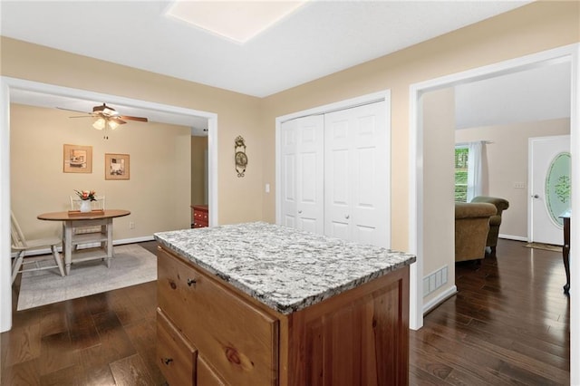 3012 Cypress Cv, Ball Ground, GA 30107 - kitchen featuring dark wood-type flooring, a kitchen island, brown cabinetry, and baseboards